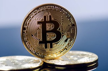 Koyu arkaplanda yansıması olan altın bitcoin sikkeler. Sanal para birimi. Şifreli para birimi. Yeni sanal para.