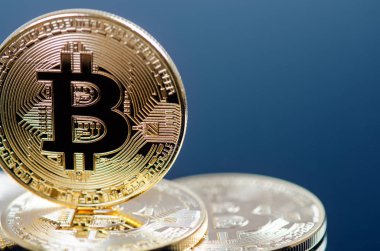 Koyu arkaplanda yansıması olan altın bitcoin sikkeler. Sanal para birimi. Şifreli para birimi. Yeni sanal para.