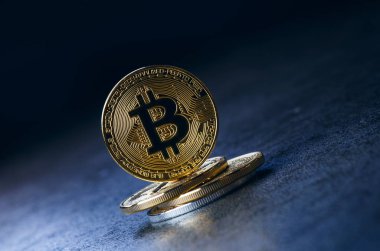 Koyu arkaplanda yansıması olan altın bitcoin sikkeler. Sanal para birimi. Şifreli para birimi. Yeni sanal para.