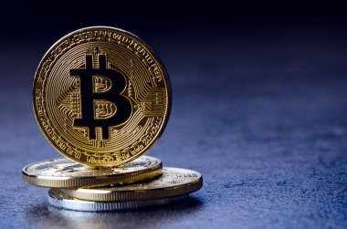 Koyu arkaplanda yansıması olan altın bitcoin sikkeler. Sanal para birimi. Şifreli para birimi. Yeni sanal para.