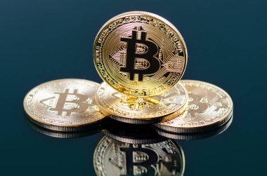 Koyu arkaplanda yansıması olan altın bitcoin sikkeler. Sanal para birimi. Şifreli para birimi. Yeni sanal para.