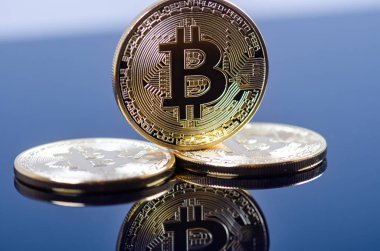 Koyu arkaplanda yansıması olan altın bitcoin sikkeler. Sanal para birimi. Şifreli para birimi. Yeni sanal para.