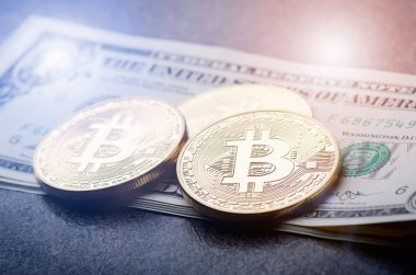 Bir kağıt dolar para ve güneş ile koyu arka plan üzerinde altın bitcoin paralar. Sanal para birimi. Kripto para birimi. Yeni sanal para dolar para. Mercek parlaması