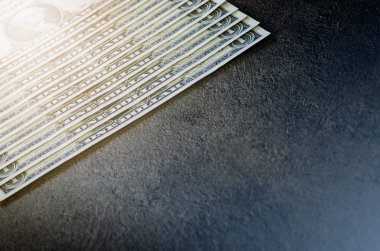 Siyah bir masanın üzerine bir dolarlık banknotlar. Nakit para Amerikan doları. Klasik arka plan. Lens fişeği. Amerikan para birimi.