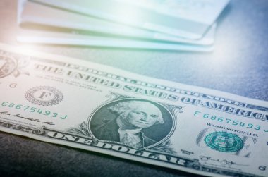 Siyah bir masanın üzerine bir dolarlık banknotlar. Nakit para Amerikan doları. Klasik arka plan. Lens fişeği. Amerikan para birimi.