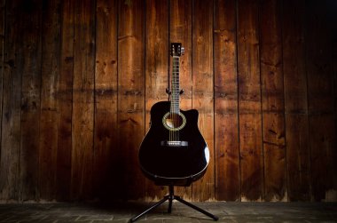 Metin ve gitarist için kopyalama alanı olan ahşap bir dokuda akustik gitar. Müzik ve eğlence konsepti. Gitar ahşap duvara dayanıyor.. 