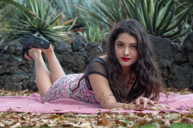 Muhteşem genç Latina rahatlatıcı parkta sıkı ve pembe Bahar elbise