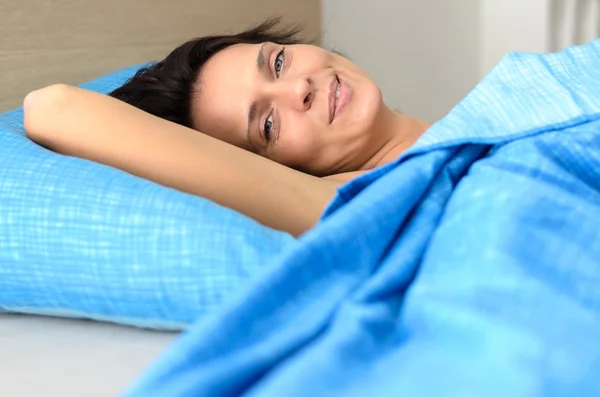 Mujer joven bonita relajándose en la cama — Foto de Stock