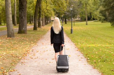 Bir bavul çekerek sarışın profesyonel kadın