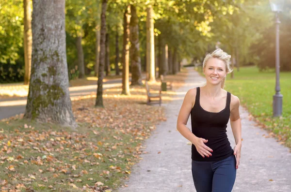 Atlética joven mujer corriendo en un parque — Foto de Stock