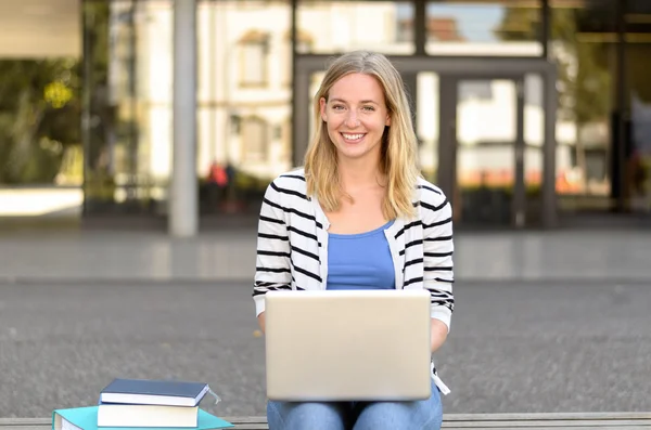 Jovem estudante sorrindo com laptop — Fotografia de Stock