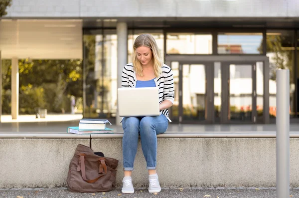 Jovem estudante do sexo feminino sentado fora usando laptop — Fotografia de Stock
