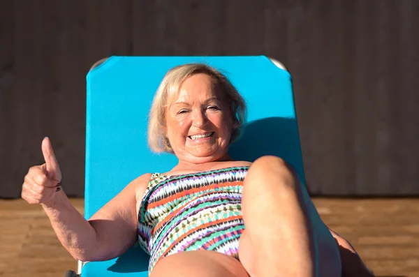 Active senior blond woman sunbathing — Stock Photo, Image