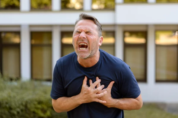 Man van middelbare leeftijd lijdt aan een hartaanval — Stockfoto