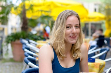 Gülümseyen kafede oturan sarışın kadın