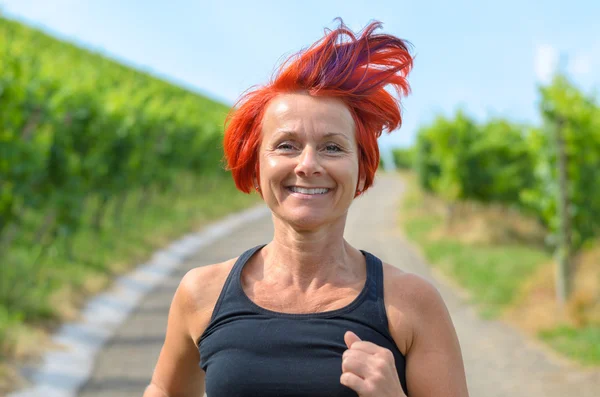 Sonriente mujer feliz corriendo en un viñedo — Foto de Stock