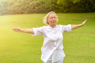 Calm woman in white clothing exercising outside clipart