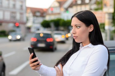 Şüpheci kadın cep telefonundan mesaj okuyor