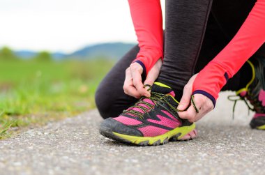 Woman bending down to tie her laces