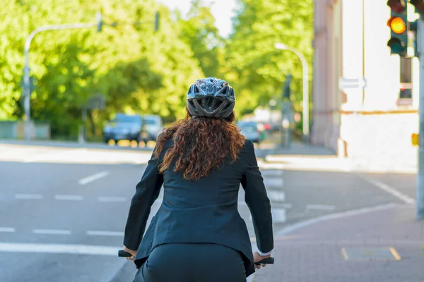 Mujer en bicicleta para trabajar en una ciudad — Foto de Stock