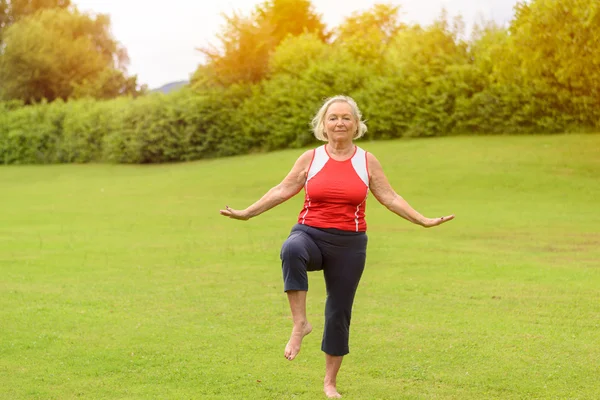 Athletic starszy kobieta wykonując ćwiczenia równowagi — Zdjęcie stockowe