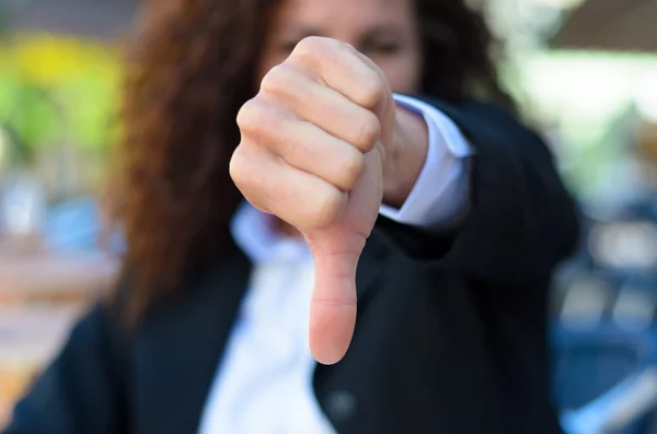 Woman making a thumbs down gesture — Stockfoto