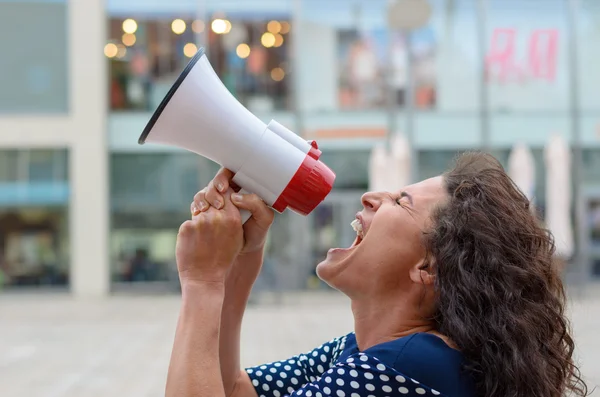 Jeune femme manifestante criant dans un mégaphone — Photo