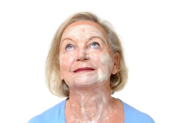 Smiling elderly lady with face cream on her skin — Stock Photo, Image