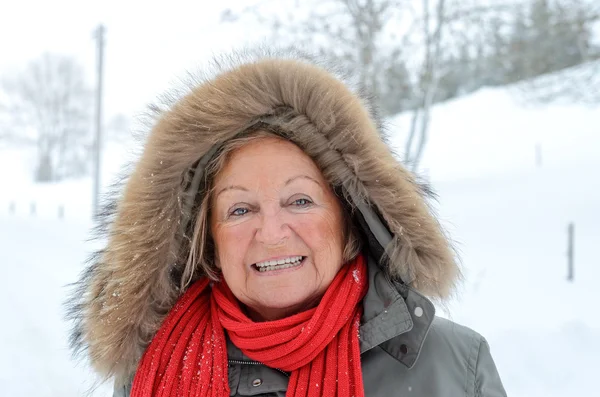 Smiling happy elderly woman outdoors in winter