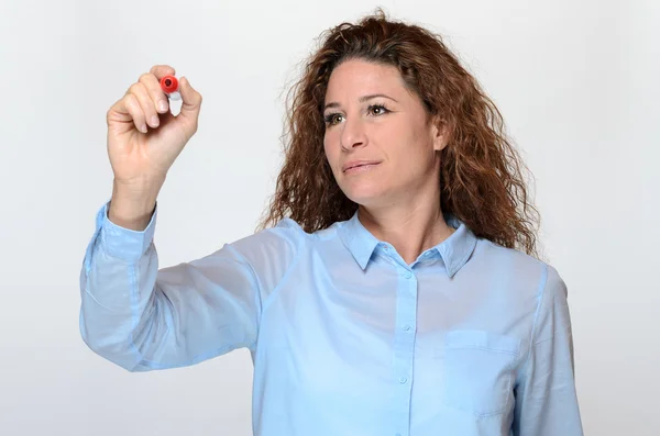 Mujer joven sonriente escribiendo con un rotulador — Foto de Stock