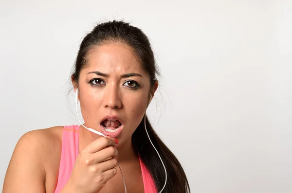 Young woman having a telephone call with her earplugs — Stock Photo, Image