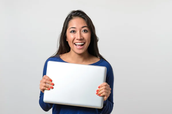 Mujer joven emocionada sosteniendo un portátil de plata — Foto de Stock