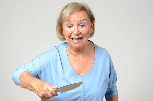 Elderly woman brandishing a kitchen knife — Stock Photo, Image