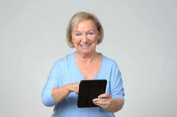 Senior woman using a wireless black tablet PC — Stock Photo, Image