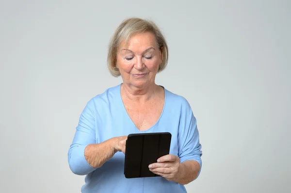 Senior woman using a wireless black tablet PC — Stock Photo, Image