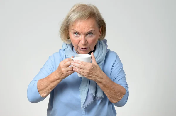 Elderly woman enjoying a hot cup of coffee — Stock Photo, Image