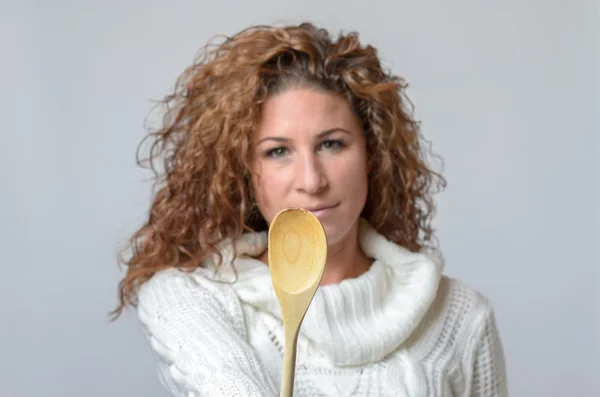 Mujer mostrando un spon de madera — Foto de Stock