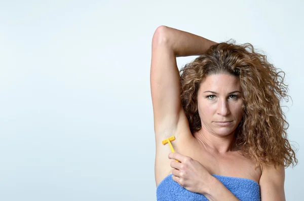 Mujer afeitando los pelos debajo de su axila — Foto de Stock