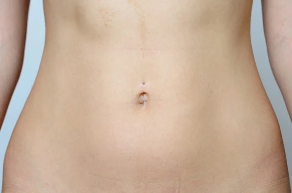 Barriga plana de uma jovem mulher nua em close up — Fotografia de Stock