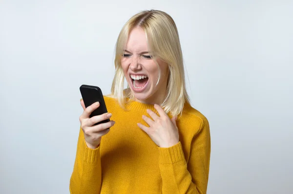 Schockierte junge Frau schaut auf ihr Handy — Stockfoto