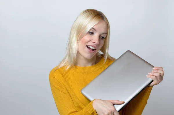 Mujer feliz sosteniendo una nueva computadora portátil — Foto de Stock