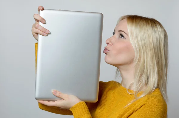 Jovem mulher beijando seu computador portátil — Fotografia de Stock