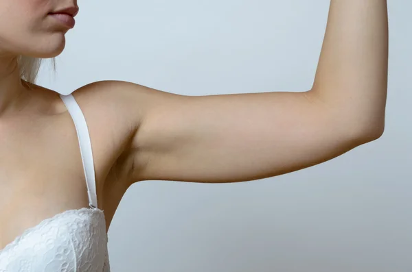 Mujer rubia joven mostrando el brazo flácido — Foto de Stock