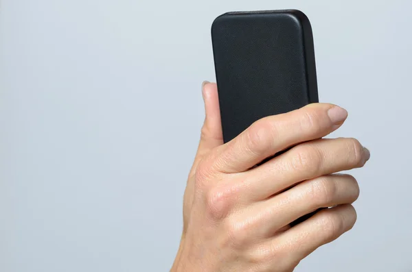 Mano che tiene un cellulare nero — Foto Stock