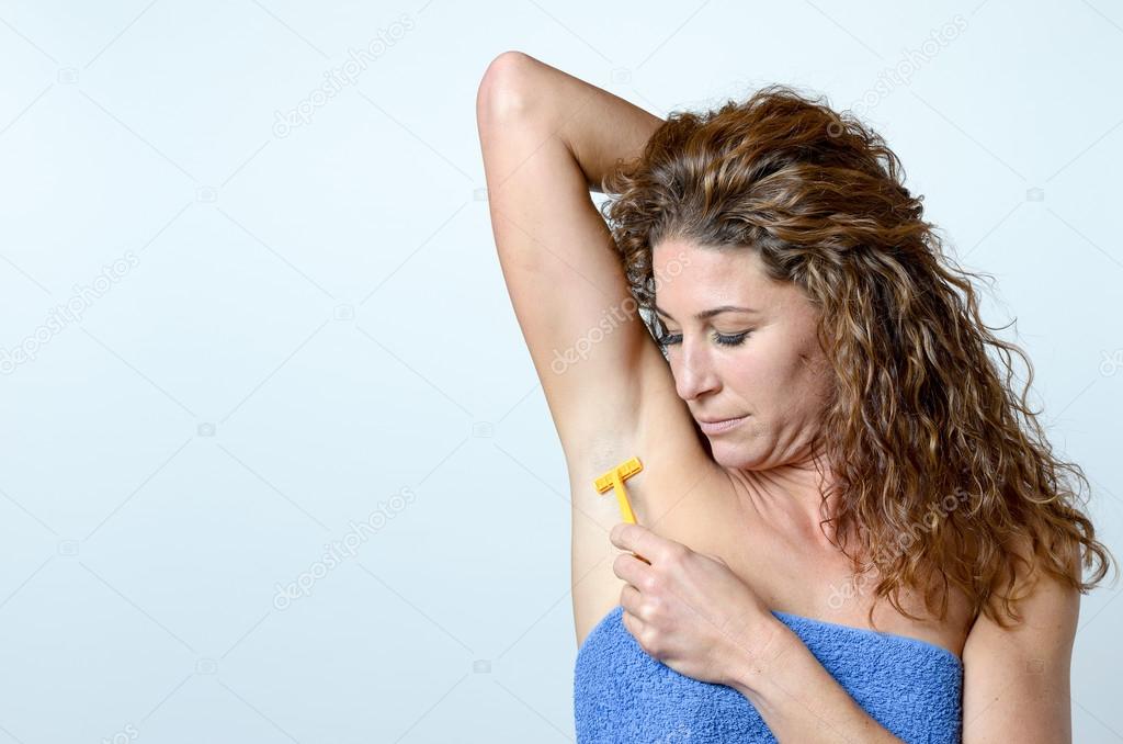 Woman shaving the hairs under her armpit