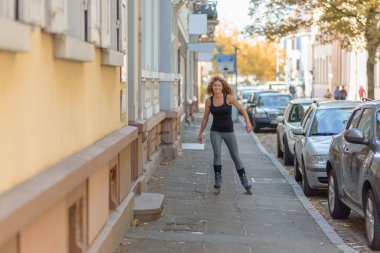 Young woman roller skating down an urban street