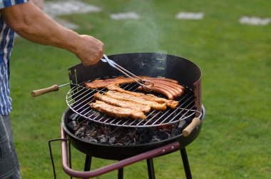 Adam bir barbekü et pişirme