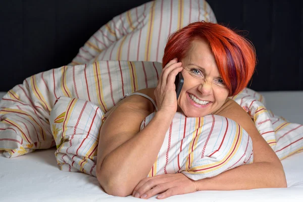 Mujer de mediana edad feliz haciendo una llamada telefónica . — Foto de Stock