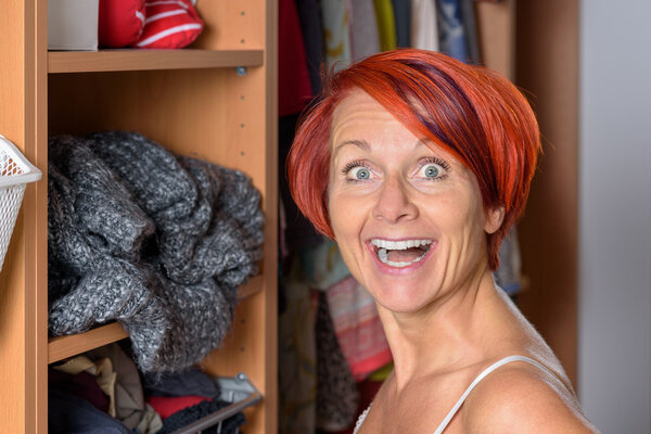 Surprised Middle Aged Woman in front of her wardrobe