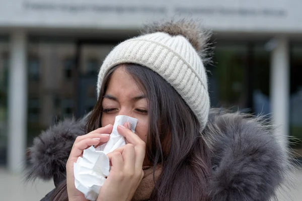 Young woman with a cold blowing her nose — Stock Photo, Image